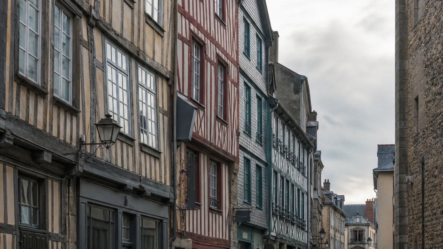 Une rue du centre de Rennes, pavée, bordée d’immeubles anciens, un matin gris.